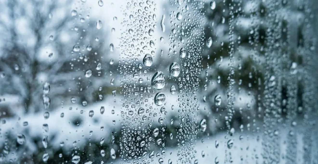 Condensation sur une vitre avec effet de flou artistique montrant l'accumulation d'humidité