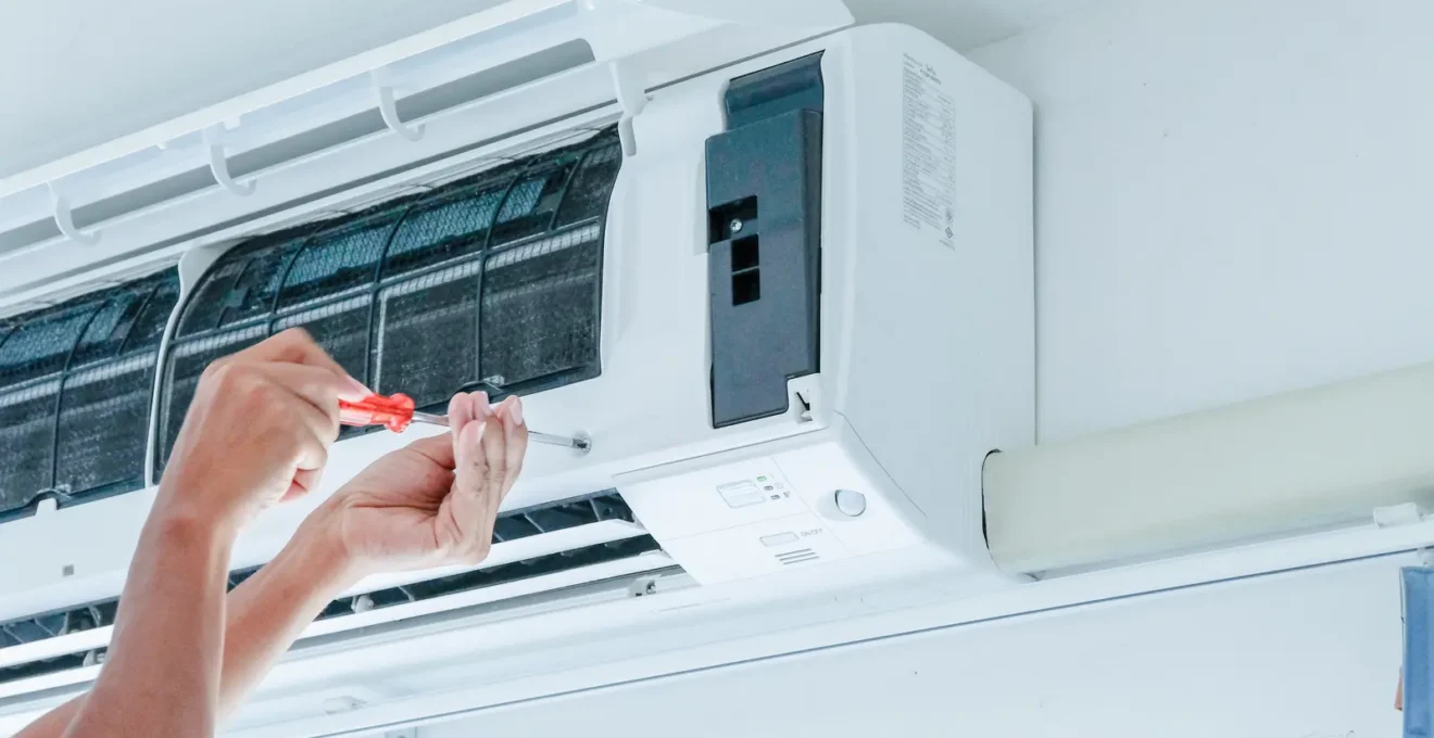 Un technicien CVCA installe une thermopompe murale dans le salon d'un duplex québécois en hiver.